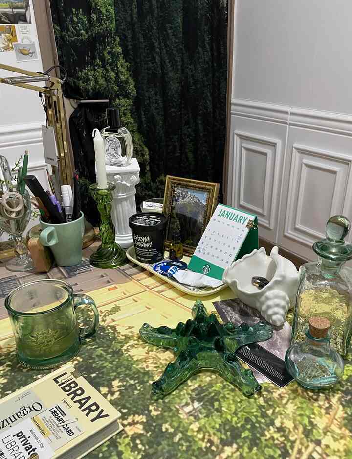Vintage style space with green and white toned table featuring decor items and candle holders
