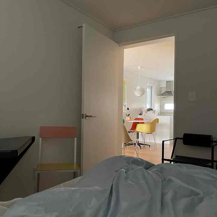 Soft natural color modern kitchen featuring colorful dining chairs in a cozy and bright interior space