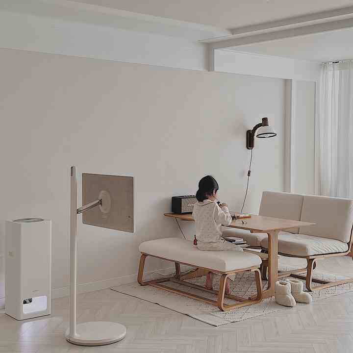 White and natural wood tone living room with bench and table centered, featuring a child sitting peacefully