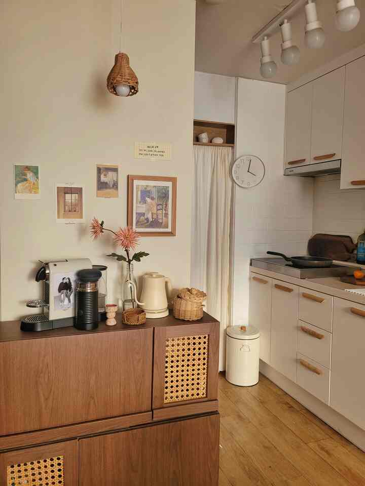Natural tone kitchen space featuring wood tone cabinets, rattan lamp, and home cafe equipment with a warm atmosphere