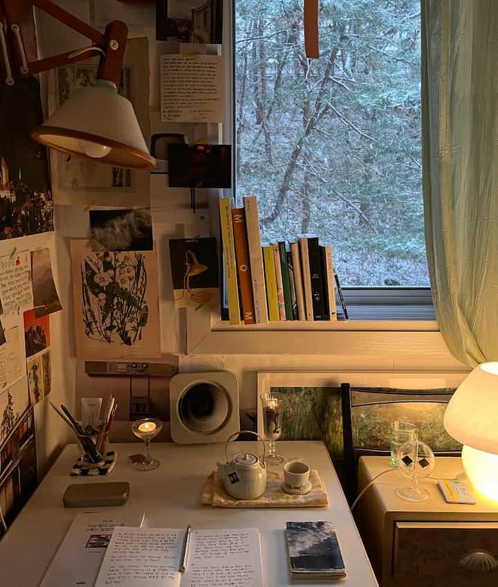 温かみのあるベージュと自然光のワンルームワークスペース、デスクにティーセットと照明が配置された居心地の良い空間