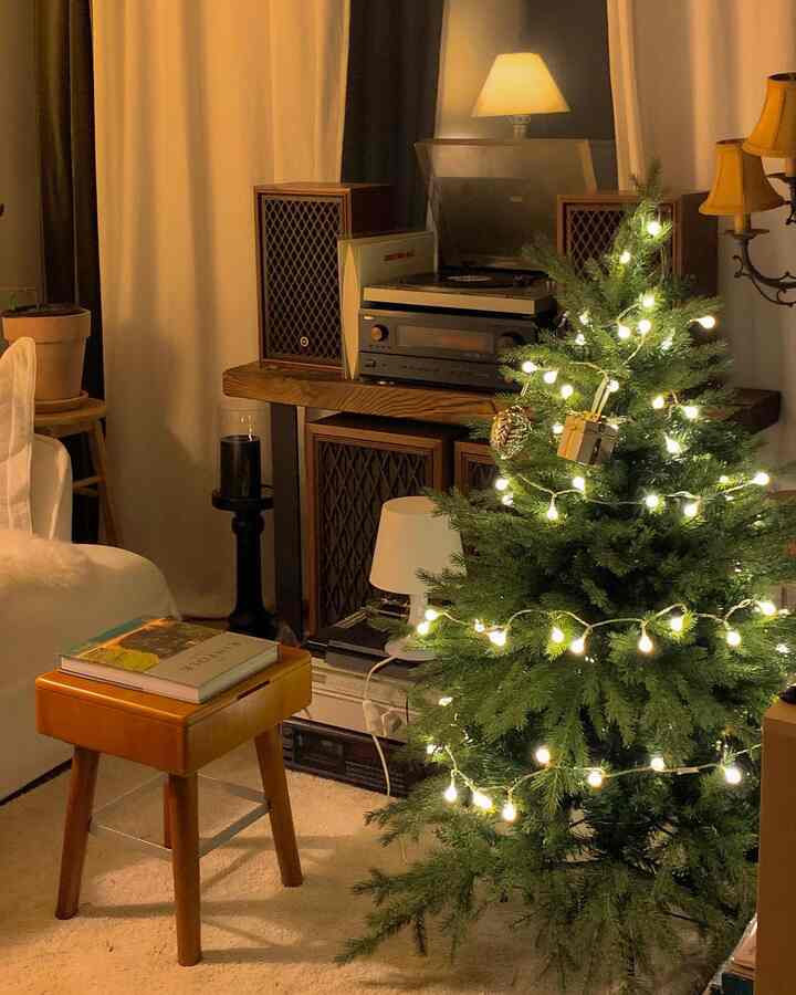 暖かみのあるブラウン調の居心地良いリビング、クリスマスツリーとレトロなオーディオが配置された自然な雰囲気のインテリア