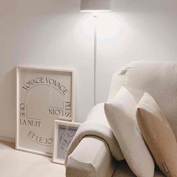 Cozy living room in warm beige and white tones featuring a textured sofa and floor lamp