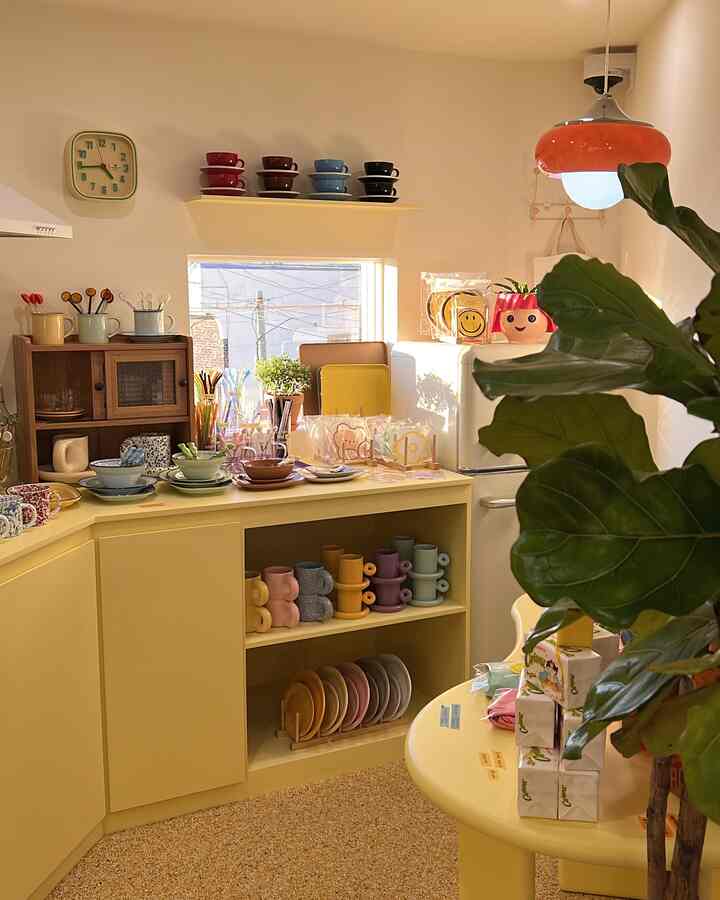 Bright yellow toned kitchen with mid-century modern style tableware and decorative items in a cozy setting