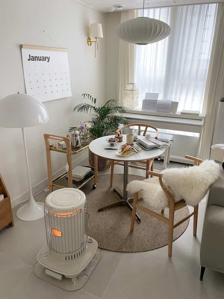 自然なナチュラルカラーのリビング、円形テーブルとシープスキンラグが居心地の良いおうちカフェの雰囲気を演出するインテリア