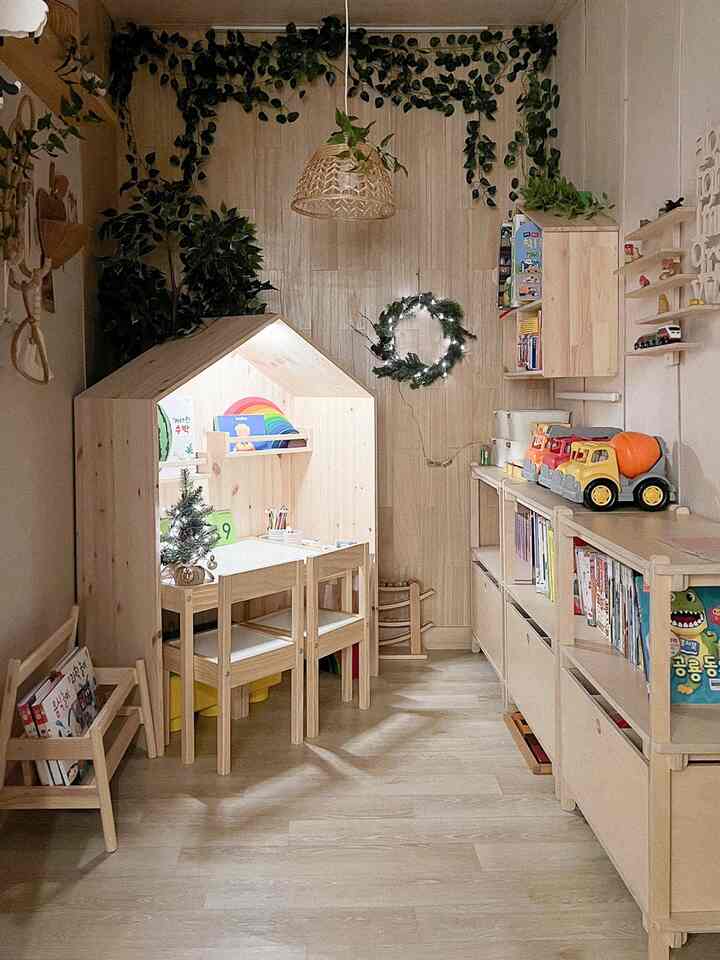 明るい木目調とプランテリアが調和した子供部屋、子供用机とおもちゃ収納が配置された雰囲気のあるインテリア