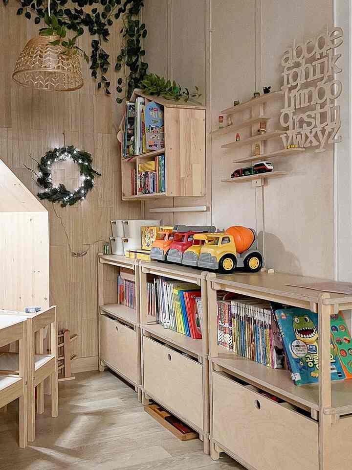 Light wood tone natural kids' room with neatly organized bookshelves and toys for children