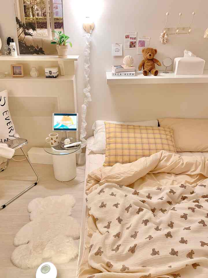 白とベージュのトーンの寝室、クマ柄の掛け布団とラグが配置された雰囲気のあるインテリア