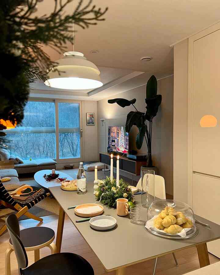 White and gray toned living and dining room featuring Christmas decorations and cozy furniture with a warm atmosphere