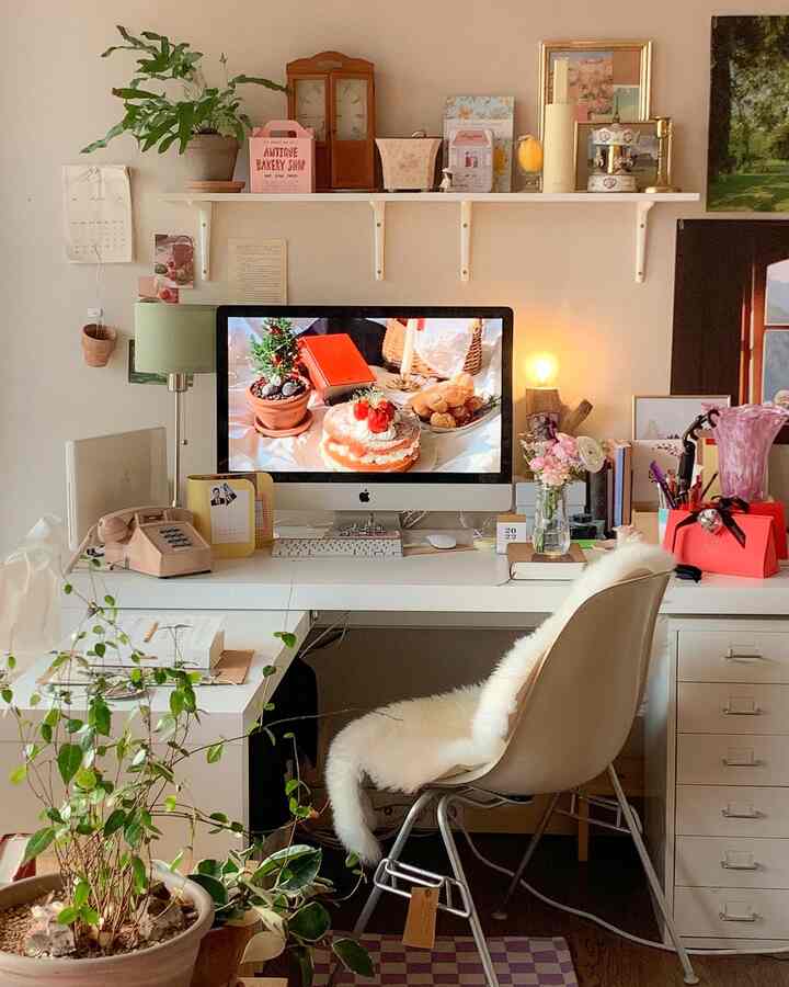 ナチュラルな色調のホームオフィス、白いデスクとオフィスチェア、緑の植物が配置された落ち着いた作業空間