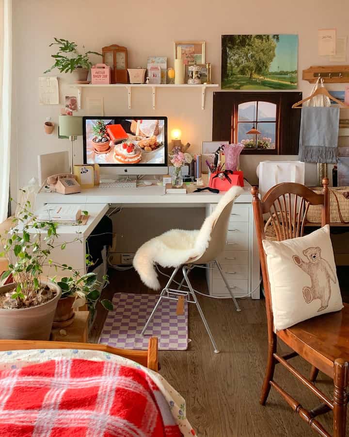 白と茶色のナチュラルトーンの寝室兼ホームオフィス、机と椅子、棚と植物が配置された雰囲気のあるインテリア