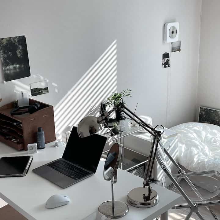 ホワイトとブラウンのトーンの一人暮らし用ホームオフィス兼寝室、すっきりしたコンパクトなレイアウトのインテリア