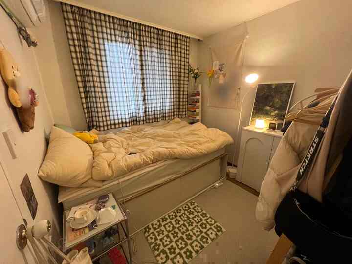 Natural beige and white toned small bedroom featuring single bed and ambient lighting creating a cozy atmosphere