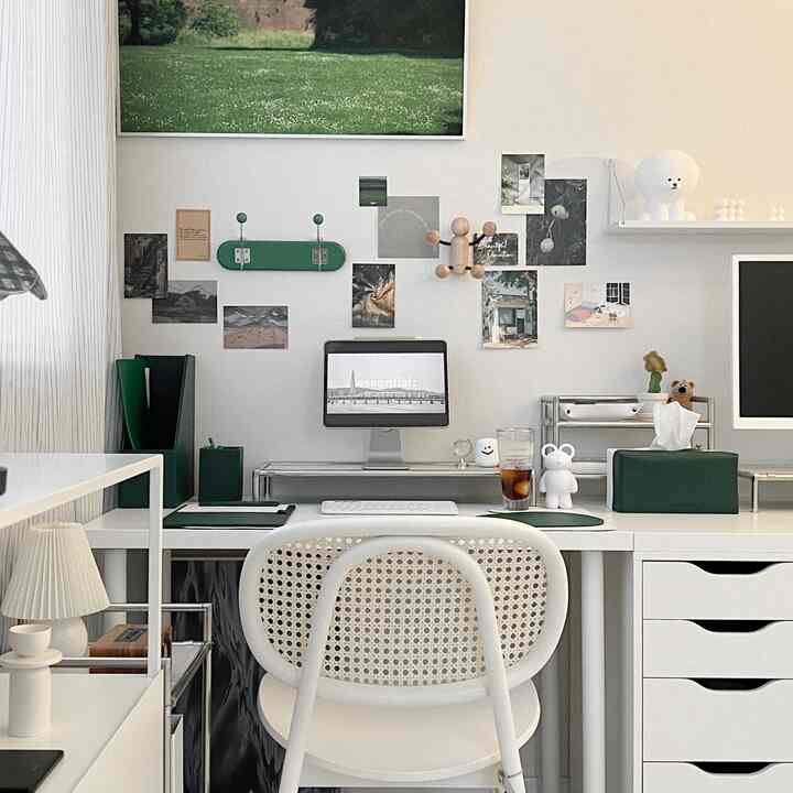 White and green toned study space featuring a tidy desk with computer and assorted decor, creating a modern workspace atmosphere