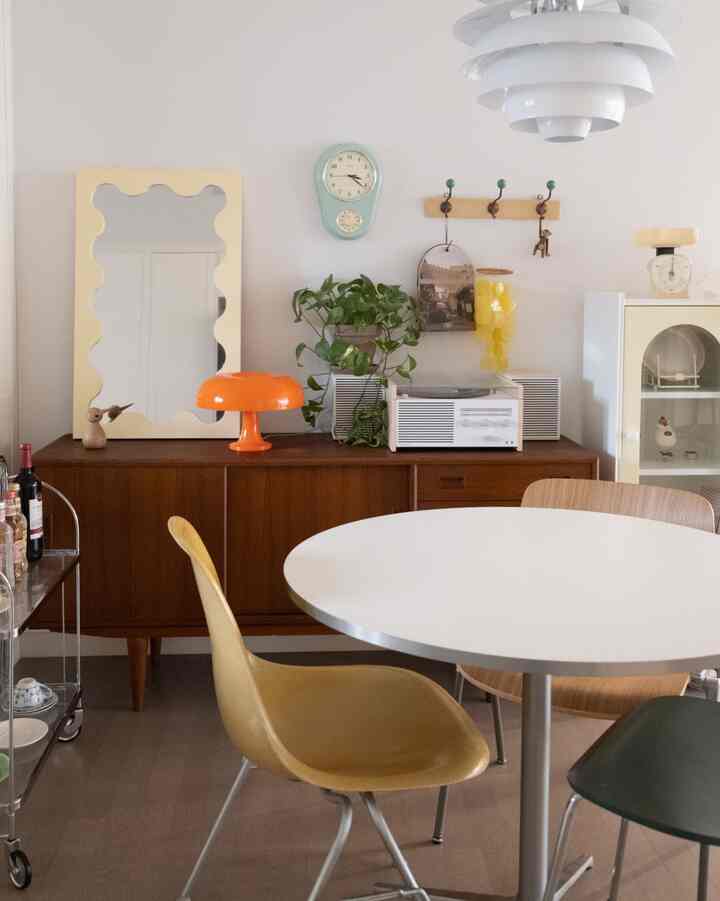 White and wood tone dining room featuring a round dining table and vintage sideboard in a cozy atmosphere
