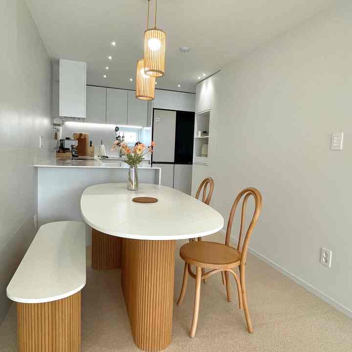 Natural modern dining area featuring a white and wood-tone kitchen and dining table
