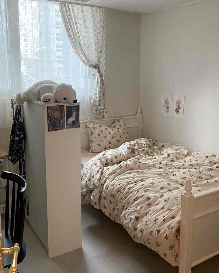 ベージュとホワイトの色調の子供部屋兼寝室、花柄寝具とレースカーテンが調和した雰囲気のある空間