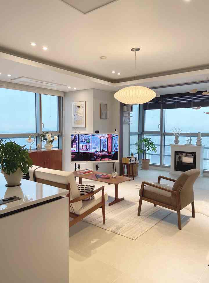 Bright white and warm wood tone mid-century modern living room featuring sofa and armchairs arranged in a cozy space
