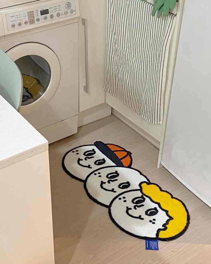 Natural and white-toned kitchen featuring a cute face-patterned rug placed on the floor, creating a cozy atmosphere