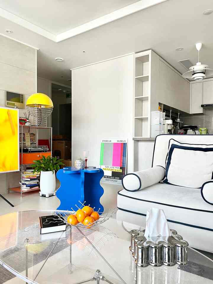 白と青のトーンのリビング、モダンなソファと透明なコーヒーテーブルがあるミニマルな空間