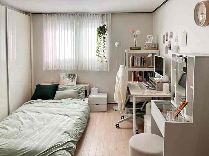 ミントグリーンとホワイトのトーンの寝室、作業スペースと化粧台が配置された清潔感のあるナチュラルなインテリア