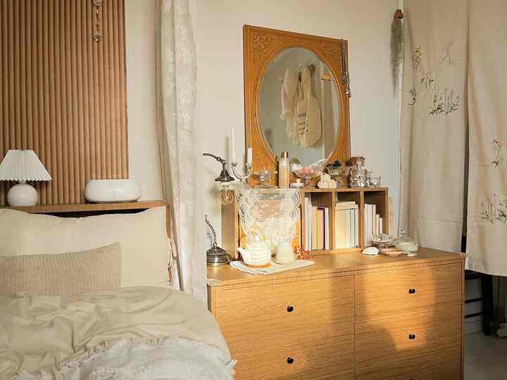 Beige and wood tone bedroom featuring wooden dresser with large mirror creating a cozy atmosphere