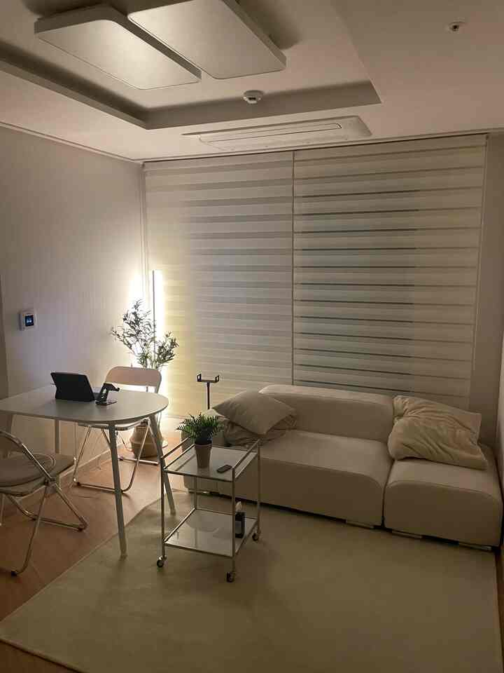 アイボリーとホワイトの色調のリビング、ソファとテーブルが調和した温かく清潔感のあるインテリア