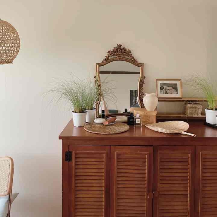 Natural wood-toned living room featuring wood cabinet, rattan lamp, and plants in a cozy setting