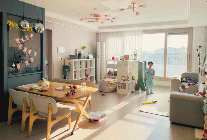 暖かい木目調と白いカーテンが調和した、子供と家族が過ごす明るく開放的なダイニングリビングスペース