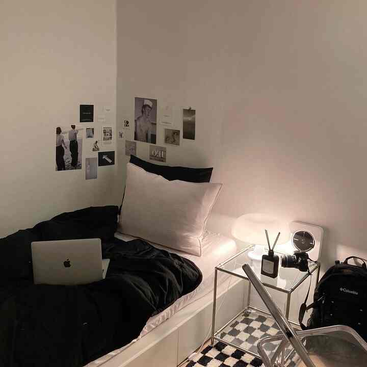 Modern and simple bedroom featuring white walls and black bedding, a cozy single-person space with Instagrammable aesthetic