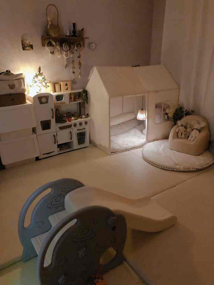Beige-toned kids' room featuring baby tent and slide with cozy, warm play atmosphere