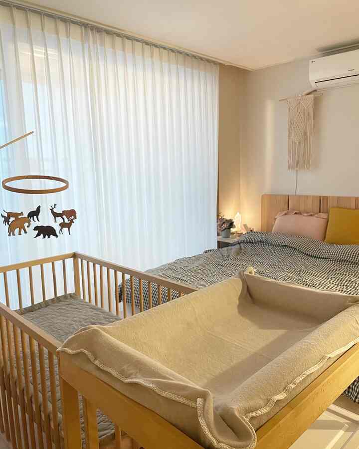 ナチュラルな色調の子供部屋兼寝室、木製家具とベージュのカーテンが温かみのある雰囲気を演出するインテリア