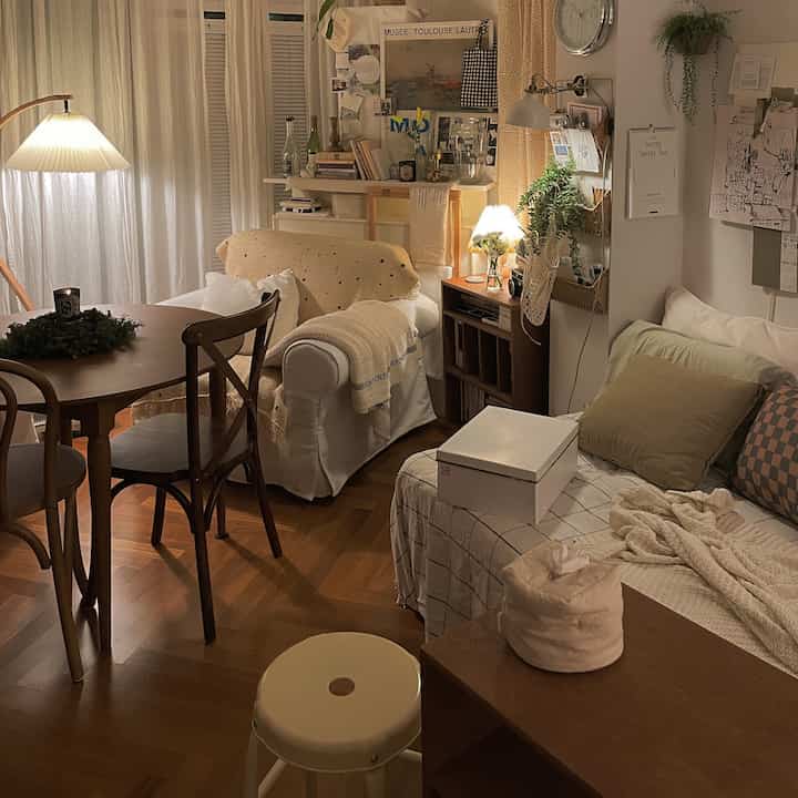 Natural wood tones and white blend in a small living room featuring warm lighting and cozy decor for a cafe-style ambiance