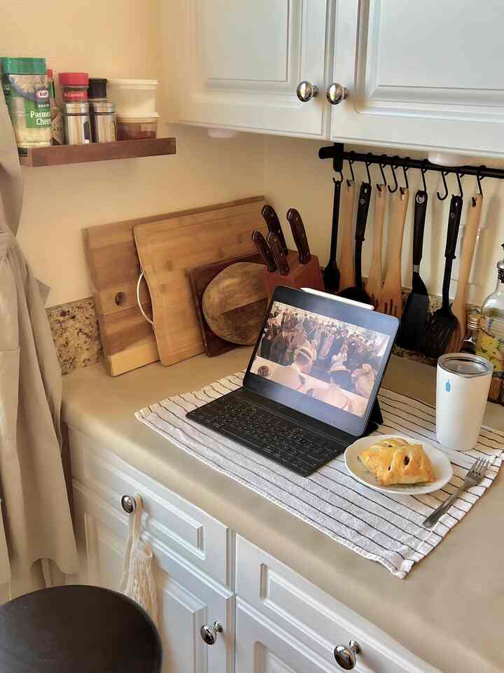Natural wood and white toned kitchen space with cooking utensils and an iPad on a cozy countertop