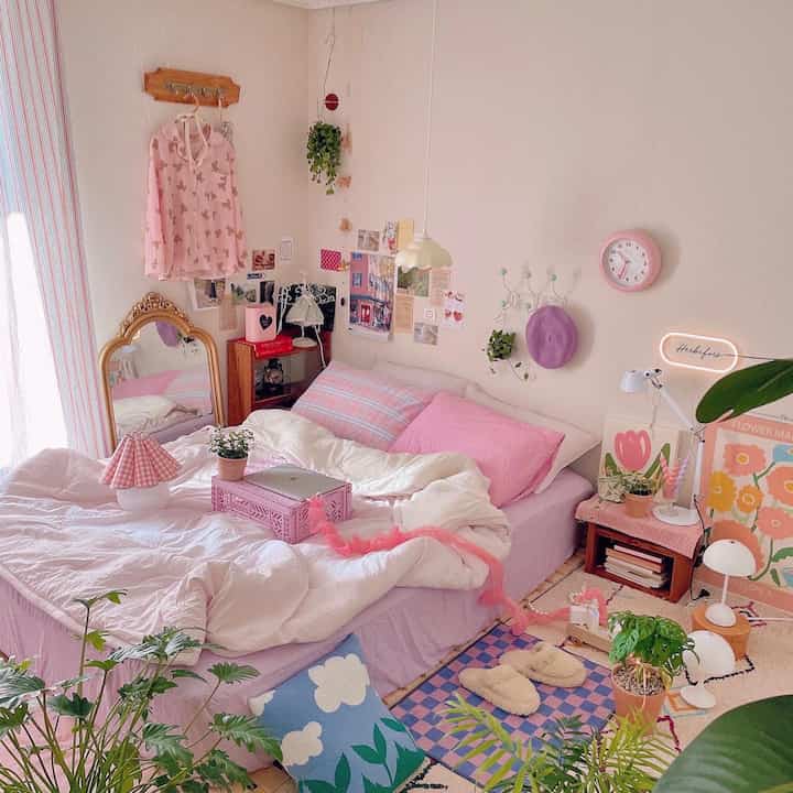 Pastel pink and purple bedroom featuring bed, rugs, and plants creating a cozy atmosphere