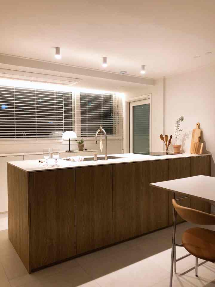 Modern kitchen space centered on a natural wood tone and white kitchen island with clean design