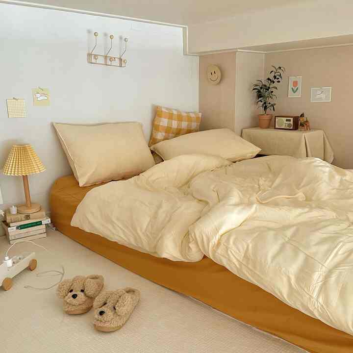 Beige and cream toned studio bedroom featuring soft bedding and cozy interior decor elements