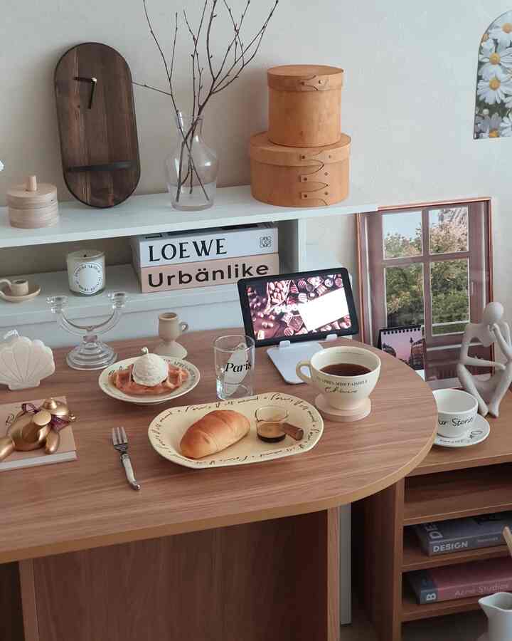Natural wood-tone dining room featuring a coffee set on the table, shelves with picture frame and clock, creating a cozy atmosphere