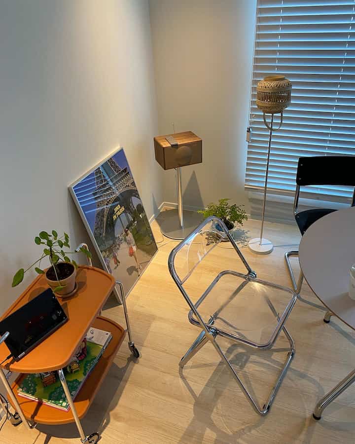 Cozy single household living room with natural wood tone flooring and a transparent chair