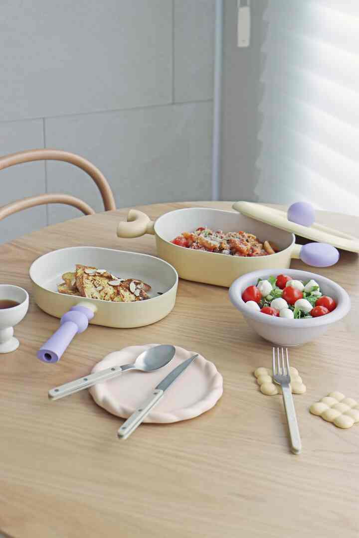 Light beige kitchenware and dining table arranged in a cozy and neat dining space