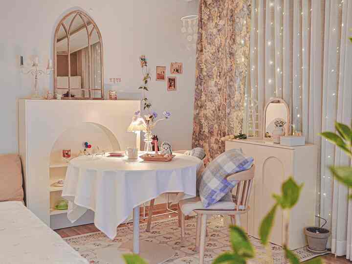 Cozy living room in white and beige tones featuring a round dining table and wood dining chair with warm ambiance