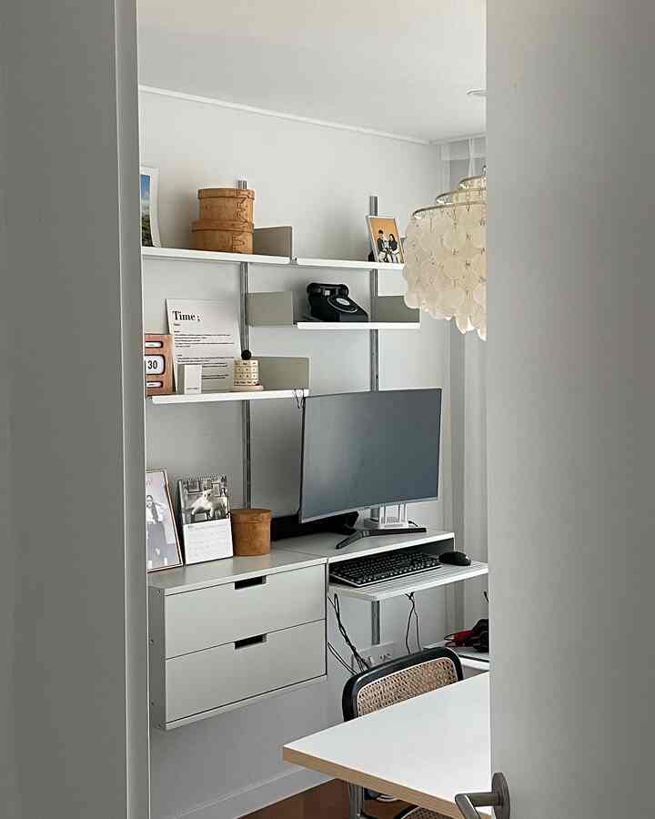 White and natural tone home office study featuring modern armchair and chandelier in a clean, bright space