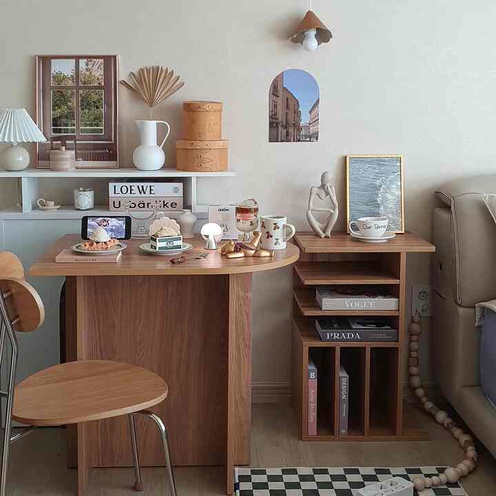 Beige and wood tone living room featuring wooden dining table, bookshelf, and home cafe accessories with cozy atmosphere