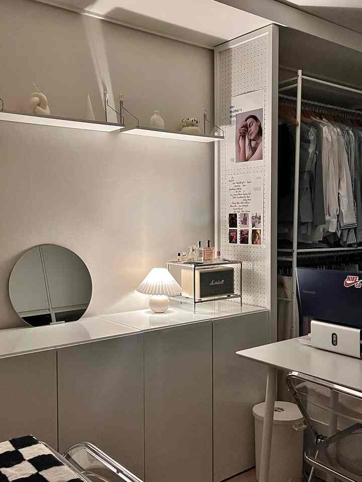 White-toned walk-in closet and vanity area with a desk, creating a clean and modern space