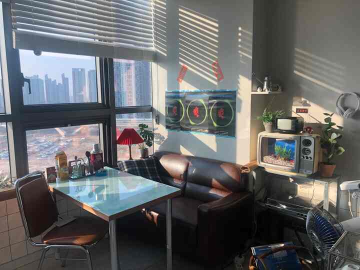 ホワイトとブラウンの色調のリビング、ヴィンテージなレトロソファとダイニングテーブルが配置され、ブラインド付きの大きな窓がある雰囲気あるインテリア