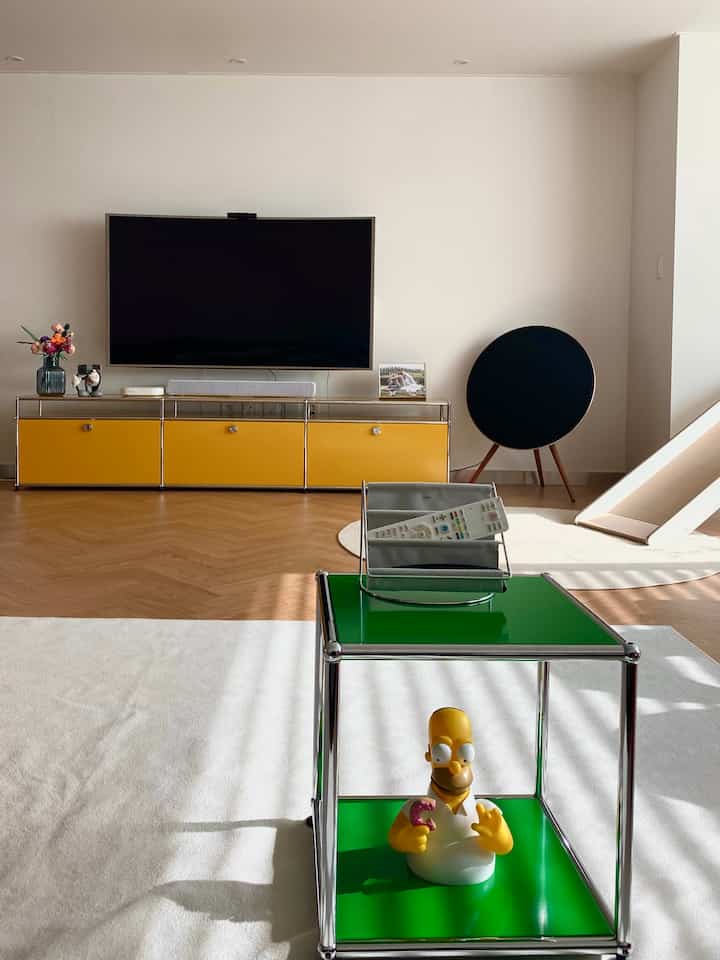 Mid-century modern living room with white walls and yellow USM Haller furniture, featuring a clean and bright atmosphere