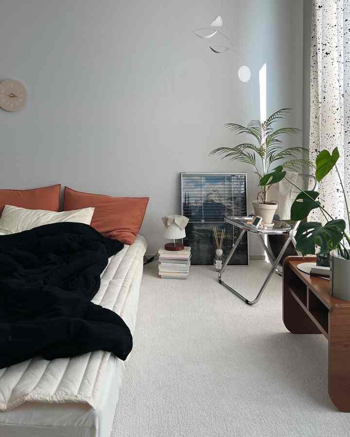 ホワイトとナチュラルカラーの寝室、ウッド家具とグリーンプラントが配置された雰囲気のあるインテリア