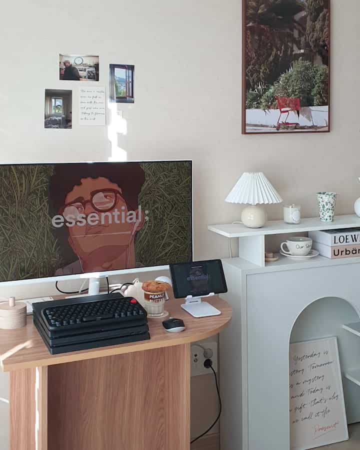 White and wood-tone home office space featuring a smart monitor and coffee cup on cozy home cafe desk setup