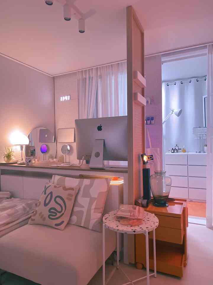 白を基調としたコンパクトな部屋、ソファとコンピュータデスク、収納が配置された雰囲気のあるホームオフィス