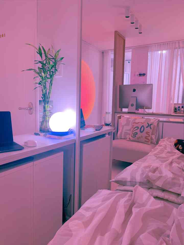 White-toned studio apartment featuring bed, sofa, and desk with modern atmosphere